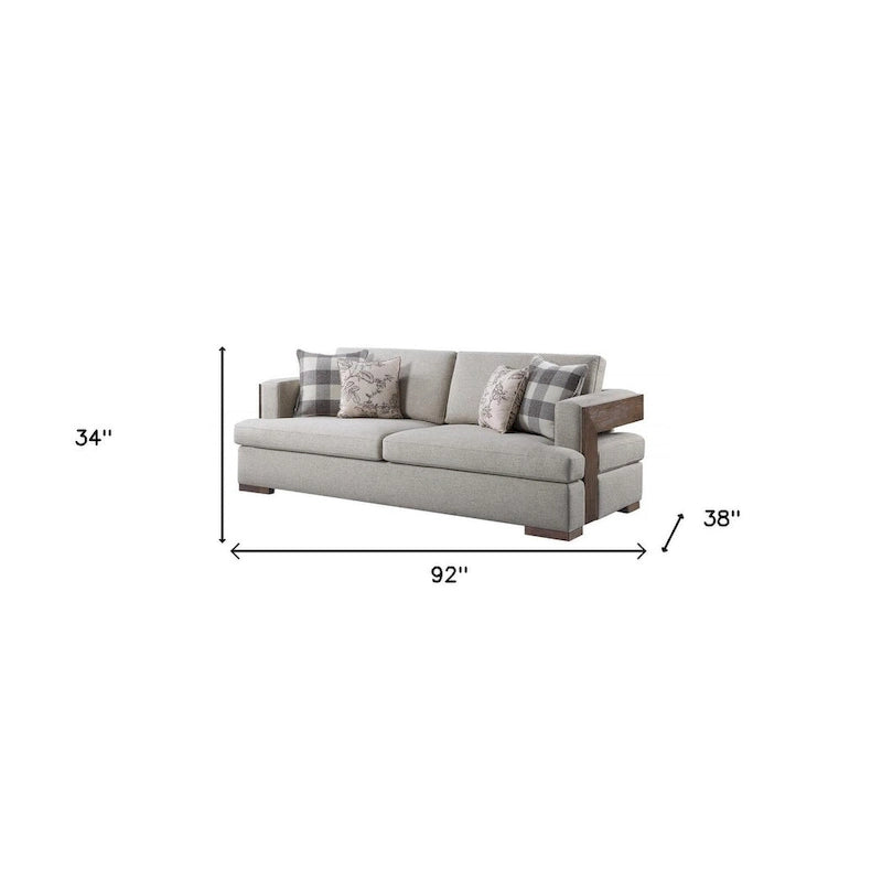 Canapé en tissu beige avec accoudoirs droits et pieds en bois massif marron